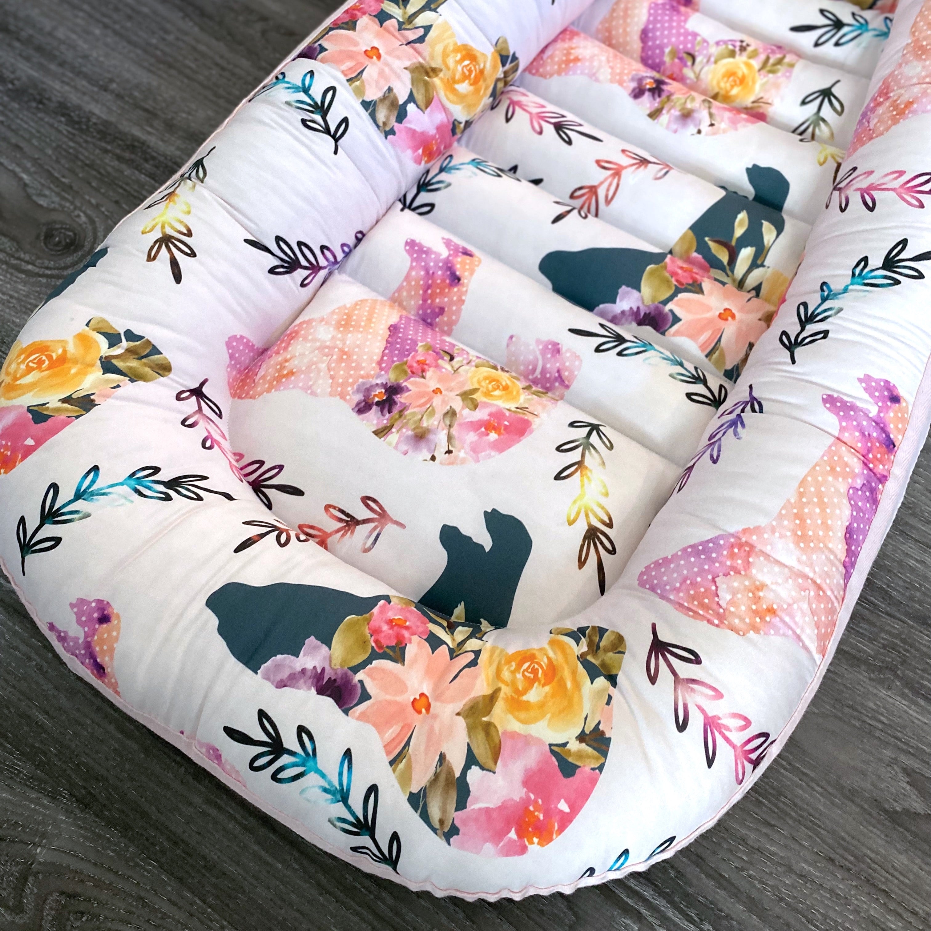baby nest , baby lounging nest, co-sleeper, similar to dockatot and snuggle me products. This one is featured in a floral bear and pink design.
